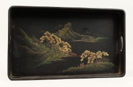 A JAPANESE BLACK LACQUER TWIN HANDLED TRAY decorated with a mountainous river landscape. 17ins