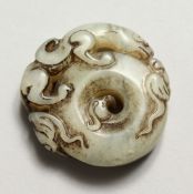 A CHINESE CARVED STONE ROUNDEL carved with leopard and bats