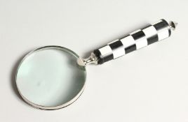A MAGNIFYING GLASS with a chequered handle.