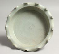 A CHINESE GREEN SHAPED DISH with wavy rim. 9ins diameter.
