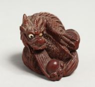A SMALL JAPANESE WOOD DRAGON NETSUKE signed