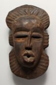 AN AFRICAN CARVED WOOD TRIBAL MASK 14.5ins high.
