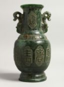 A CHINESE CARVED TWO HANDLED JADE VASE 9.5ins high.