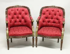 A PAIR OF MAHOGANY AND BUTTON UPHOLSTERED ARMCHAIRS, with parcel gilded carved show wood frames,