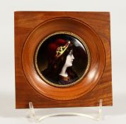 A LIMOGE CIRCULAR PLAQUE OF A YOUNG LADY 2.5ins diameter, in a mahogany frame.