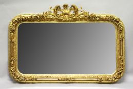 A LARGE DECORATIVE GILT FRAMED OVERMANTLE MIRROR, with ornate cresting and floral decorated frame.