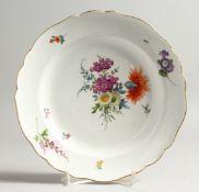 A 19TH CENTURY MEISSEN CIRCULAR PLATE with waved border and painted with flowers. Crossed swords