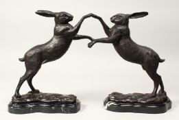 A PAIR OF BOXING BRONZE HARES on a marble base 12ins high.