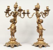 A PAIR OF 19TH CENTURY FRENCH BRASS CHERUB FIVE LIGHT CANDELABRA 20ins high.