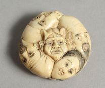 A CARVED BONE FIVE FACE NETSUKE 1.25ins diameter