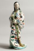 A PORCELAIN FIGURE OF A WOMAN 9.5ins high.