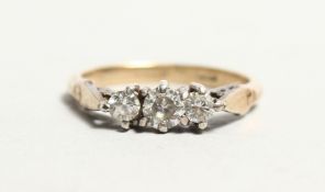 AN 18CT GOLD THREE STONE DIAMOND RING.