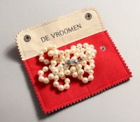 AN ART DECO STRING OF EIGHTY SEVEN PEARLS with diamond clasp.