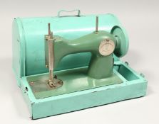 A CHILD'S TIN PLATE SEWING MACHINE AND COVER 10ins long