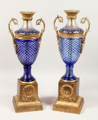 A LARGE PAIR OF BOHEMIAN CUT GLASS TWO-HANDLED VASES with blue overlay and gilt metal mounts on