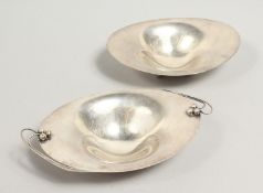 A PAIR OF CONTINENTAL SILVER OVAL DISHES, one with scroll work handles, on four ball feet 5.5ins &