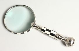 A MAGNIFYING GLASS with a chequered handle.