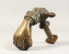 A GOOD CAST BRONZE DOOR KNOCKER, modelled as a hand holding a ball 7ins long