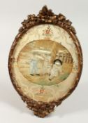A GEORGIAN OVAL SILKWORK GILT FRAMED PICTURE OF THREE CHILDREN