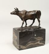 A SMALL BRONZE BULL 5ins long on a marble base.