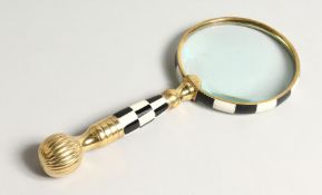 A MAGNIFYING GLASS with a chequered handle.