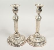 A PAIR OF LOUIS XVITH CANDLESTICKS on circular bases. 11ins high.