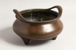 A LARGE CHINESE BRONZE TWO HANDLED CENSER on four feet.