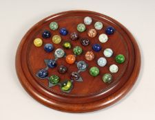 A LARGE 19TH CENTURY MAHOGANY CIRCULAR SOLITAIRE BOARD 13.5ins diameter with thirty three 2cm