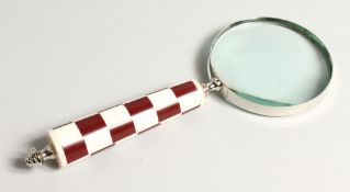 A MAGNIFYING GLASS with a chequered handle.