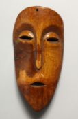 A CARVED BONE MASK, possibly LEGA 6.5ins x 3ins.