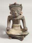 AN AFRICAN POTTERY FIGURE, a man seated with his legs crossed. 10ins high.