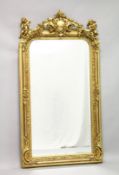A LARGE DECORATIVE GILT FRAMED MIRROR, the shaped top mounted with cherubs. 5ft 3ins high x 2ft 9ins