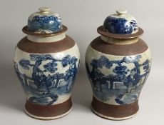A PAIR OF CHINESE BLUE AND WHITE TEMPLE JARS AND COVERS 16ins high.