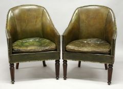 A GOOD PAIR OF LEATHER TUB ARM CHAIRS with brass studs on tapering legs.