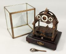 A GOOD THREE DIAL ROLLING BALL CLOCK on a stand with single drawer, with glass cover. 16ins high,