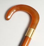 A GOOD AMBER WALKING STICK with 18ct gold band