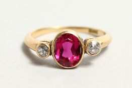 AN 18CT GOLD, DIAMOND AND RED STONE RING.