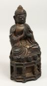 A BRONZE SEATED GOD, calligraphy on its back, 11ins high