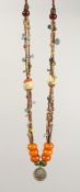 AN ETHNIC BEAD NECKLACE, mounted with six amber beads.