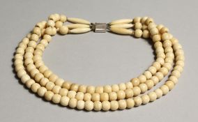 A BONE THREE ROW BEAD NECKLACE, with white metal clasp. 17ins long