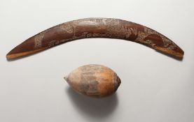 A CARVED WOOD BOOMERANG and a similarly carved nut (2). Boomerang 21ins long.