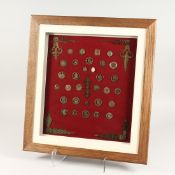 A COLLECTION OF FRAMED COINS, TIE PINS, BUTTONS, MEDALLIONS, AND CLOCK HANDS 17ins x 15ins.