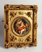 A GOOD GERMAN PORCELAIN CIRCULAR PLAQUE, Madonna and child 5.5ins diameter, in a gilded frame.