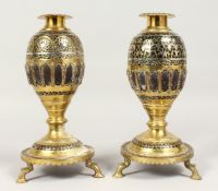 A PAIR OF ISLAMIC SILVER AND BRASS MOUNTED COCONUT STICK VASES. 10ins high.