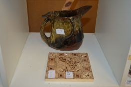 An old tile and an unusual pottery jug.