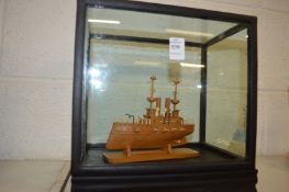 A Japanese carved box wood model of a gun ship, in a display case.