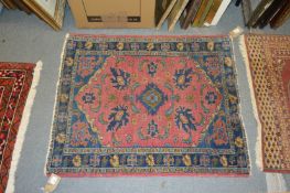 A small pink ground Persian rug.