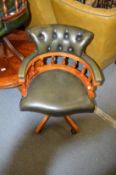 A good modern green leather upholstered and beech framed revolving desk chair.