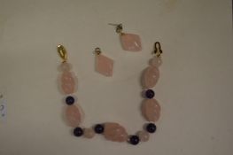 A rose quartz necklace and earrings.