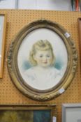 An oval portrait of a young girl watercolour, in a decorative gilt frame.